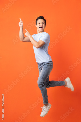 Asian man jumping and pointing