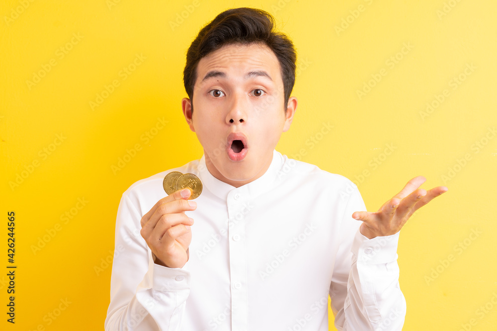 Asian businessman holding bitcoin in his hand wite happy face Asian businessman holding bitcoin in his hand wite happy face