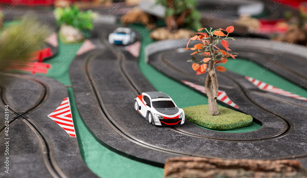 Electric slot cars on the toy race track ready to play in playroom