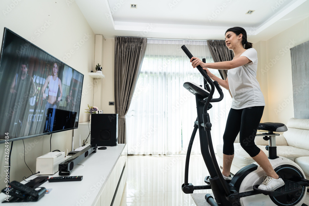 Fototapeta premium Asian girl doing exercise by learning online from video tutorial.