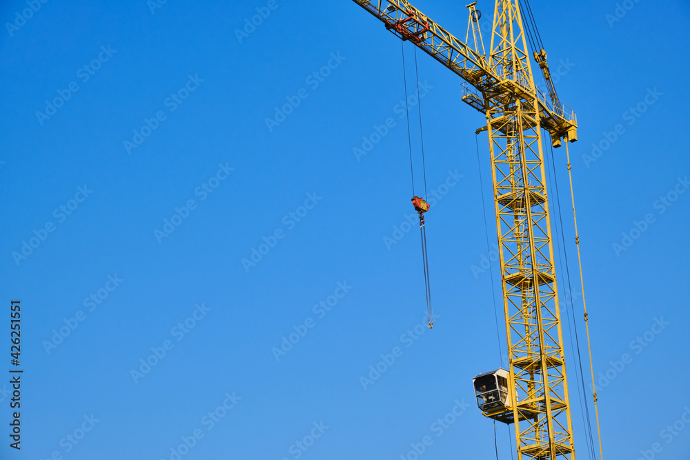 Construction crane against blue sky rests after working day Construction crane against blue sky rests after working day