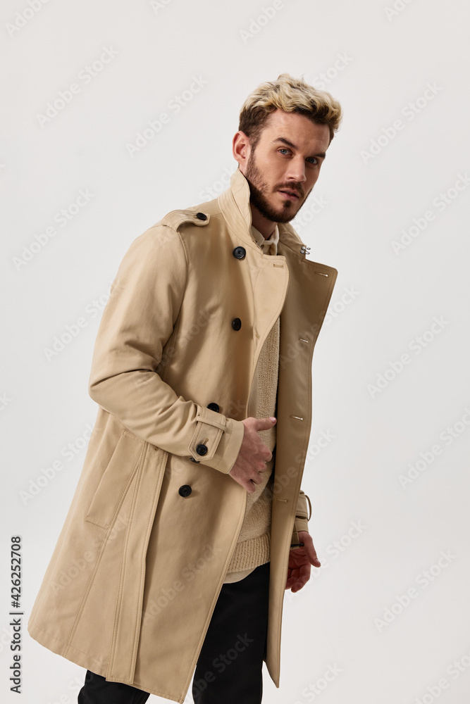 a man in a beige coat bent over to the side and fashionable pants suit  hairstyle Stock Photo | Adobe Stock
