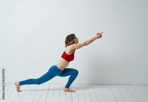 Sporty Woman In A Bright Room And Does Yoga Asana Exercises