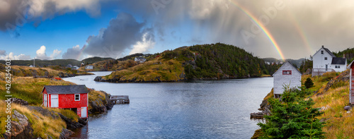 View of a small town on the Atlantic Ocean Coast. Colorful Sky with Rainbow Art Render. Taken in Salt Harbour, Newfoundland and Labrador, Canada.