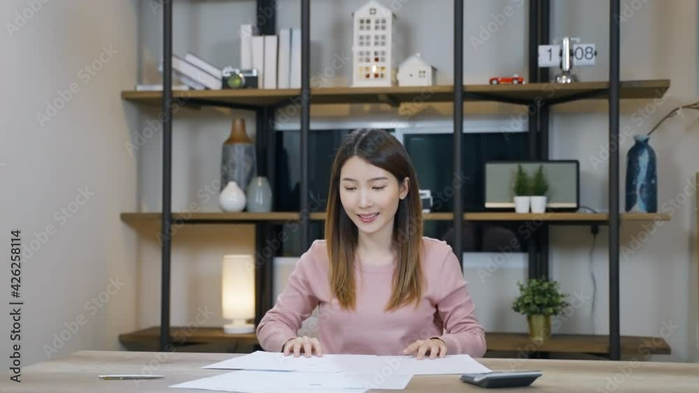 Slow motion Cheerful Asian woman working on desk. Female success the job throwing paper sheets on the air. Happiness and successful concept. Slow motion Cheerful Asian woman working on desk. Female success the job throwing paper sheets on the air. Happiness and successful concept.