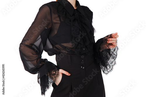 Stylish cute young businesswoman in black elegant blouse and hat on white light background. Woman in fashionable clothes posing at camera. Concept of style, fashion, beauty and achievement of goals