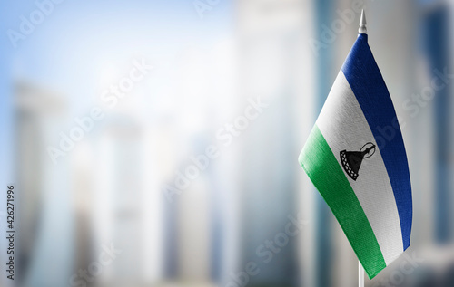A small flag of Lesotho on the background of a blurred background