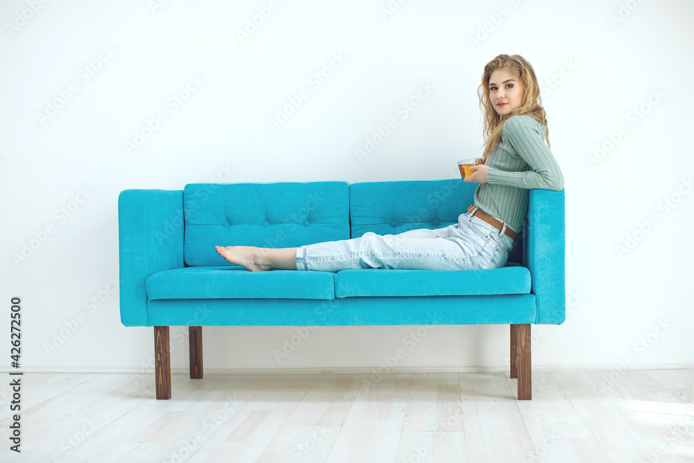 Young woman sitting at home and drinking tea, interior. High quality photo. Young woman sitting at home and drinking tea, interior. High quality photo.