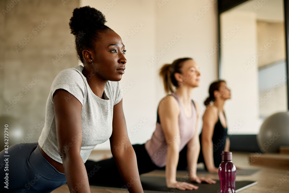 African American athletic woman stretching during exercise class