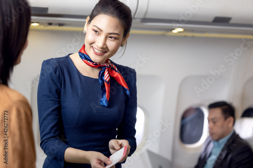 Billede på lærred Cabin crew or Stewardess greeting passengers on airplane, Air hostess or steward