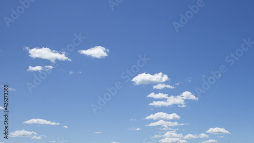 Small cumulus clouds against the blue sky. Background.