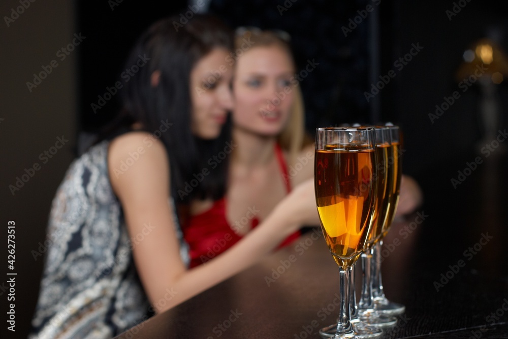 Young women in bar. Focus on glasses Young women in bar. Focus on glasses