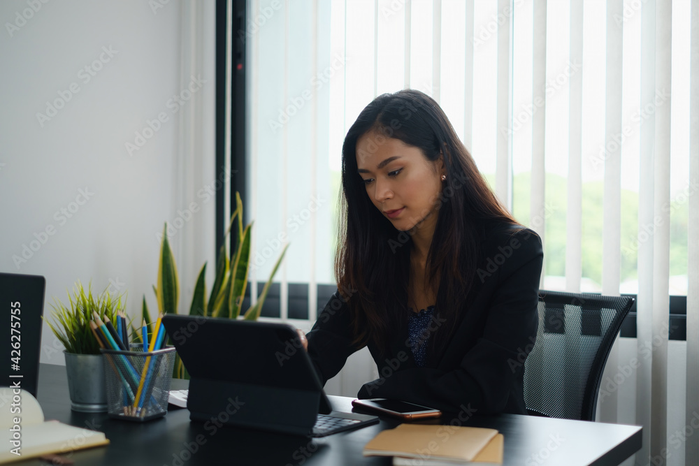 Portrait of beautiful accountant sitting at desk with interior drinking hot beverage holding cup with coffee looking at digital tablet while video conference. Portrait of beautiful accountant sitting at desk with interior drinking hot beverage holding cup with coffee looking at digital tablet while video conference.