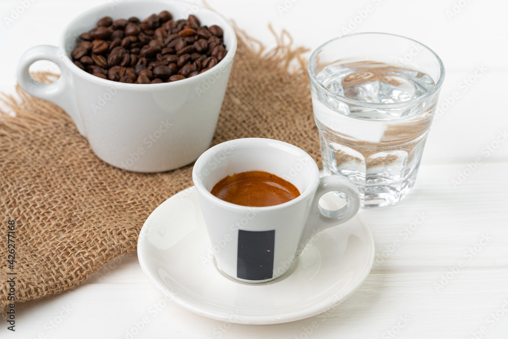 Cup of espresso with glass of water on white table Cup of espresso with glass of water on white table