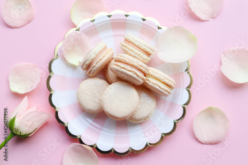 Light Pink Macarons on the twisted white and pink plate on pink background 