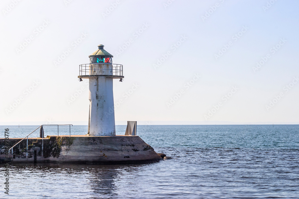 Lighthouse on a pier with the water horizon