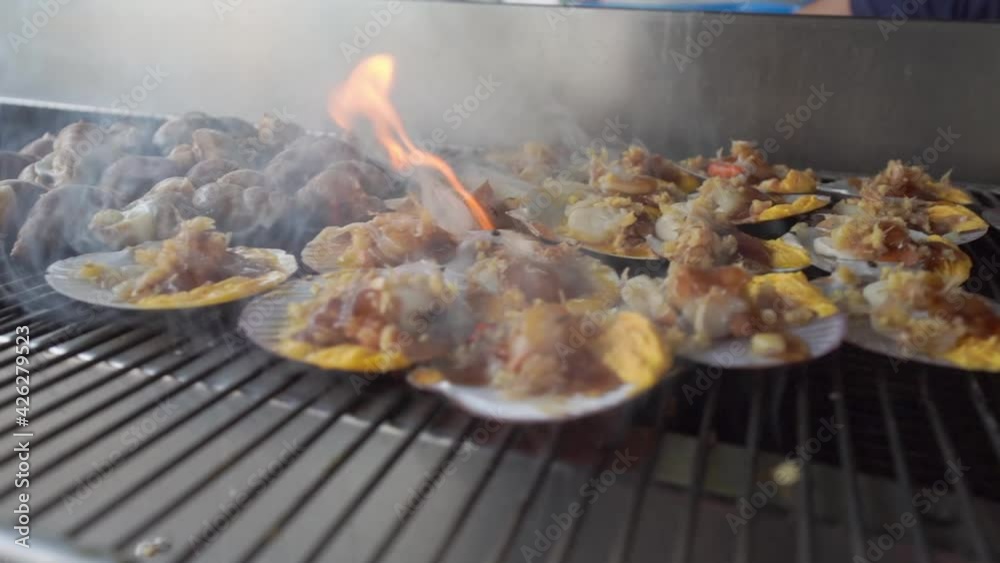 Slow Motion Grilling Fresh Seafood on Flame Grilled scallops with garlic butter Slow Motion Grilling Fresh Seafood on Flame Grilled scallops with garlic butter