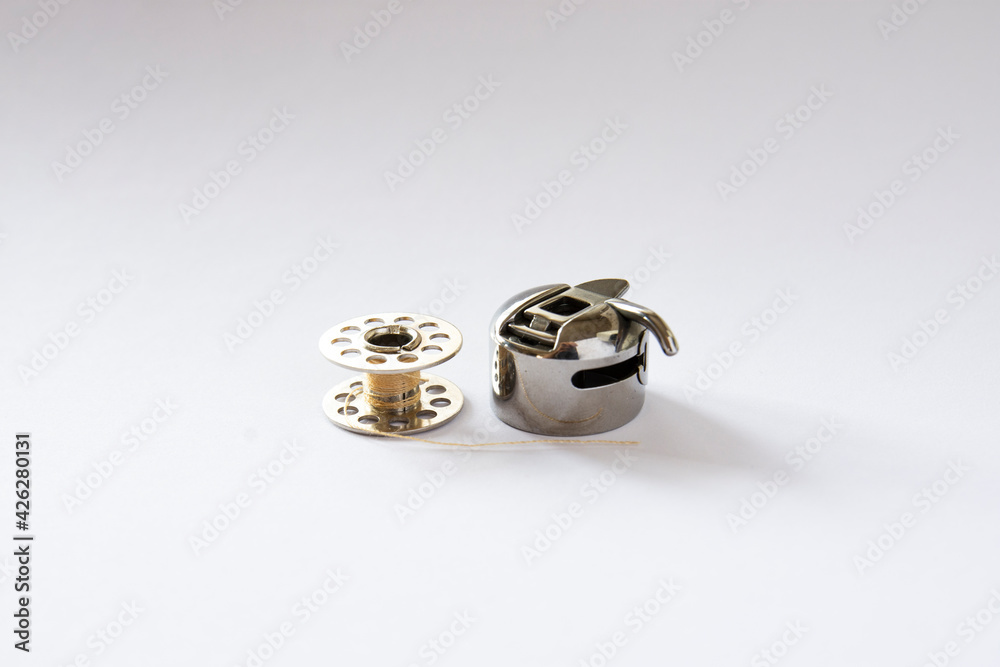 sewing machine bobbin and bobbin case. isolated white background. Selective Focus object sewing machine bobbin and bobbin case. isolated white background. Selective Focus object
