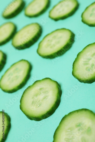 Fresh ripe cucumber slices on mint background