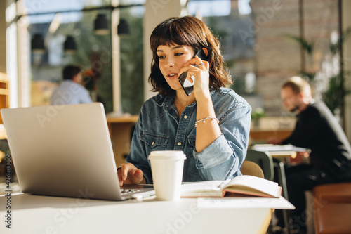 Freelancer talking with client over cell phone photo