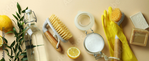 Cleaning concept with eco friendly cleaning tools and lemons on beige background