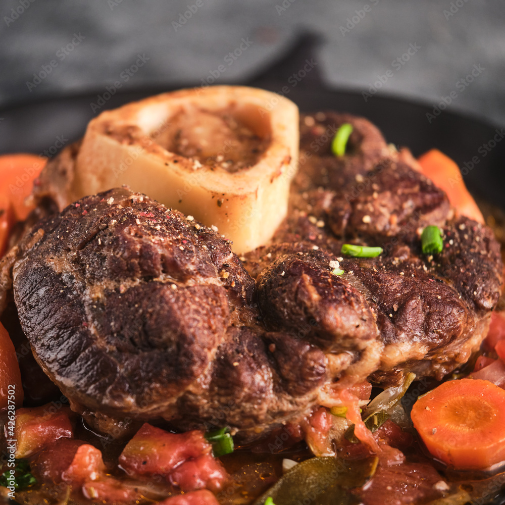 Beef Leg Slice with marrow. Italian menu: braised veal steak Ossobuco alla Milanese with vegetable sauce. Selective fosus. Beef Leg Slice with marrow. Italian menu: braised veal steak Ossobuco alla Milanese with vegetable sauce. Selective fosus.