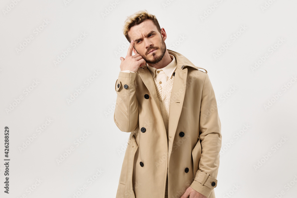 a man with a serious expression holding his hand near his head fashion modern style