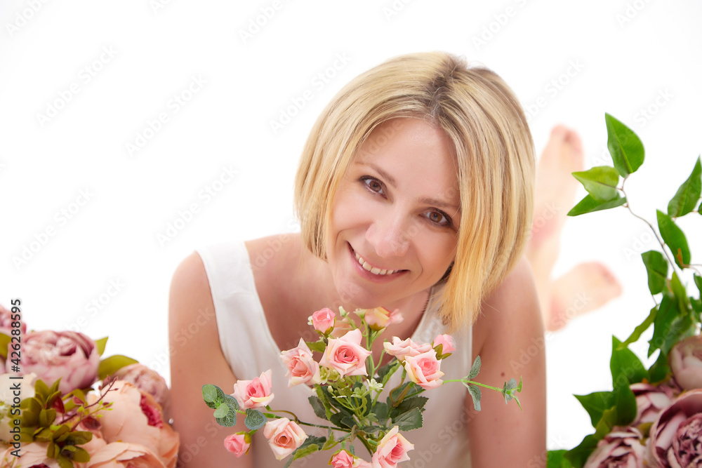 Pretty skinny girl with beautiful flowers on a white background in photo studio