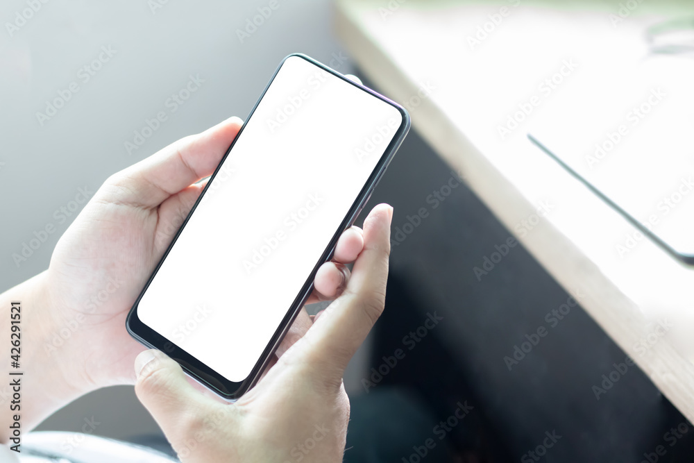 Hand holding and using smartphone with white blank on screen. Hand holding and using smartphone with white blank on screen.