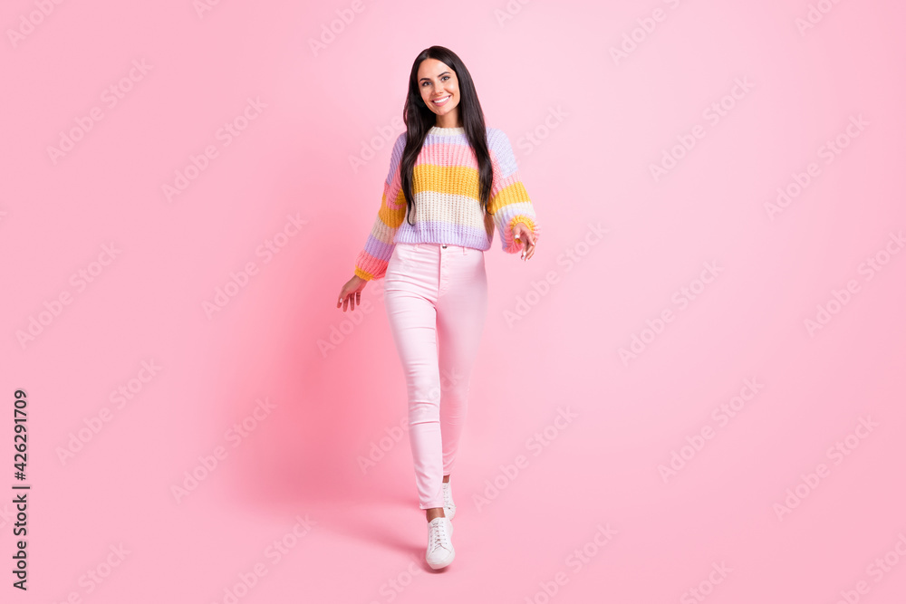 Full length body size view of pretty thin cheerful girl walking wearing cozy clothes good mood isolated over pink pastel color background Full length body size view of pretty thin cheerful girl walking wearing cozy clothes good mood isolated over pink pastel color background