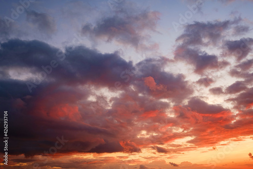 Calm sea with sunset sky and sun through the clouds over.