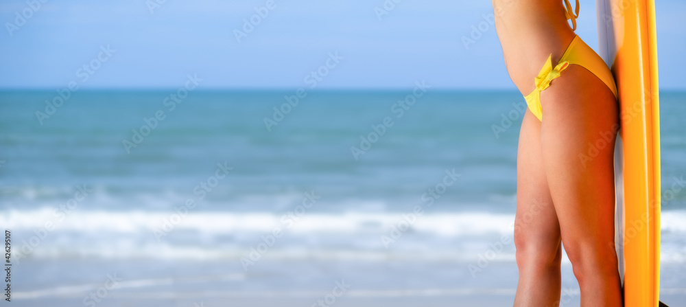 Beautiful female body wearing yellow bikini standing and the sea background coppy space design banner for web Beautiful female body wearing yellow bikini standing and the sea background coppy space design banner for web
