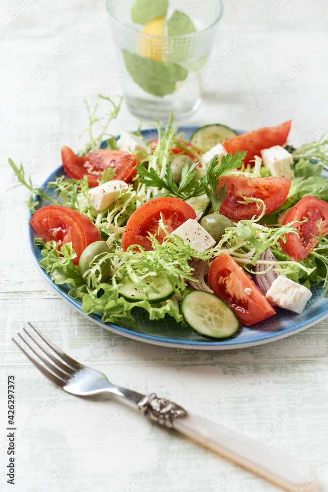 Salad with Green Olives, Tomatoes and Feta Cheese. Bright wooden background. Close up. Salad with Green Olives, Tomatoes and Feta Cheese. Bright wooden background. Close up.