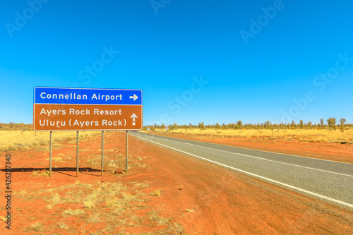 Uluru, Northern Territory, Australia - Aug 22, 2019: Lasseter Highway signboard direction Connellan Airport, Ayers Rock Resort and Uluru. Tourism in Central Australia, Red Centre. Dry season.