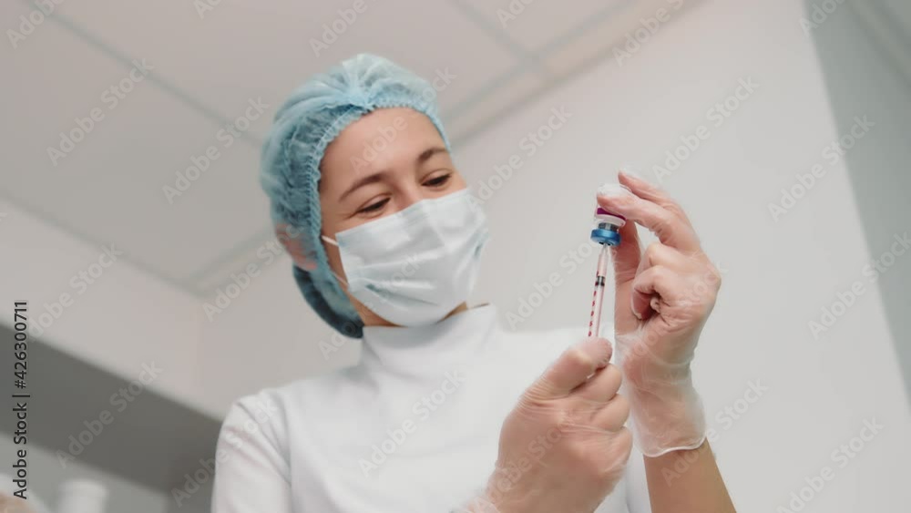 Nurse draws the vaccine into the syringe and prepares for the vaccination. A young nurse in a medical institution is vaccinated against coronavirus, influenza, and other diseases. Nurse draws the vaccine into the syringe and prepares for the vaccination. A young nurse in a medical institution is vaccinated against coronavirus, influenza, and other diseases.