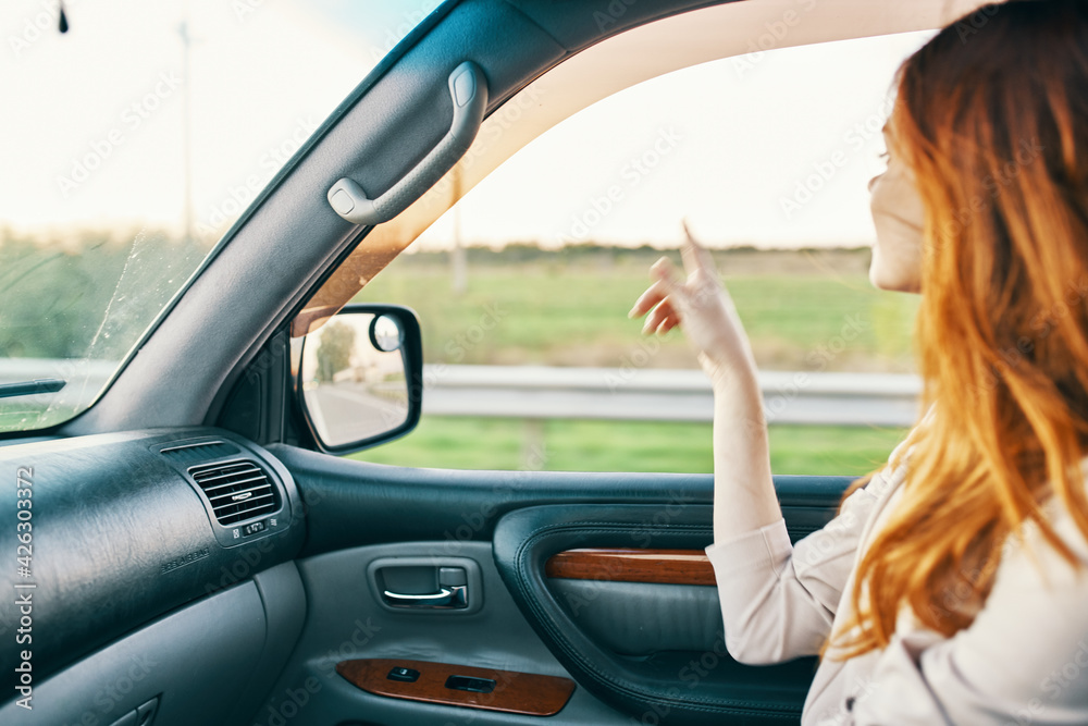 happy woman in sweater driving on the front seat of a car clean interior design model