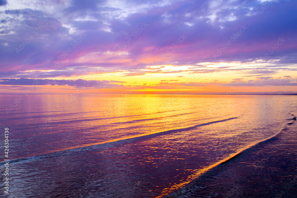 Colorful clouds on sunset, with beautiful reflection on sea water. Evening summer scenery view. Baltic Sea in Jurmala resort, Latvia. Relax, vacation concept