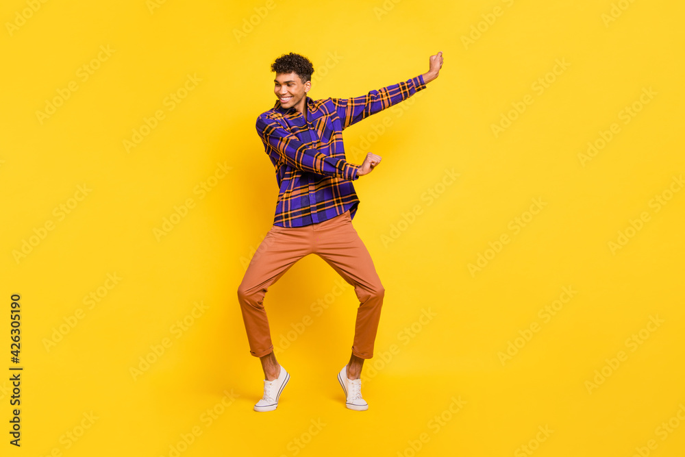 Full size portrait of cheerful dark skin person enjoy dancing have good mood isolated on yellow color background