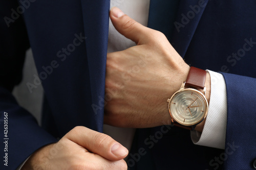 Businessman in jacket with luxury wrist watch, closeup
