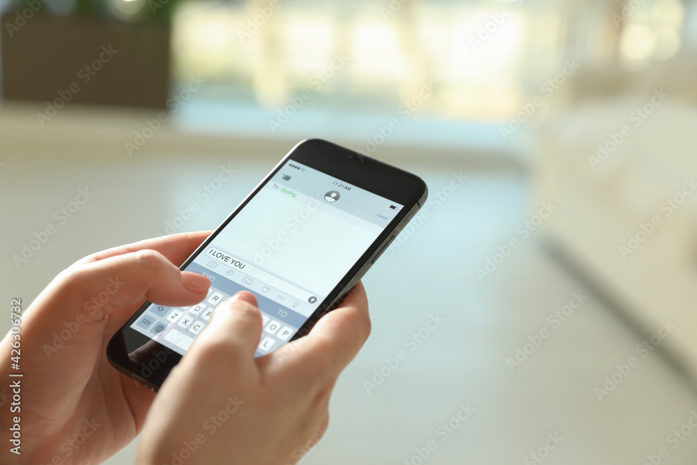 Woman writing message I Love You on smartphone against blurred background, closeup. Space for text Woman writing message I Love You on smartphone against blurred background, closeup. Space for text