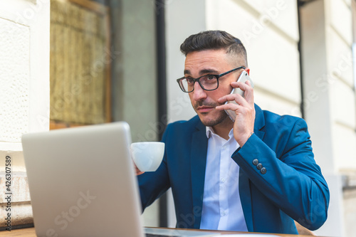 Businessman Having Phone Call in a Cafe Outdoors.