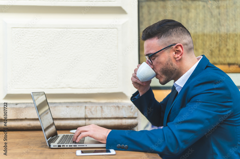 Fototapeta premium Businessman Using Laptop While Drinking Coffee in a Cafe.