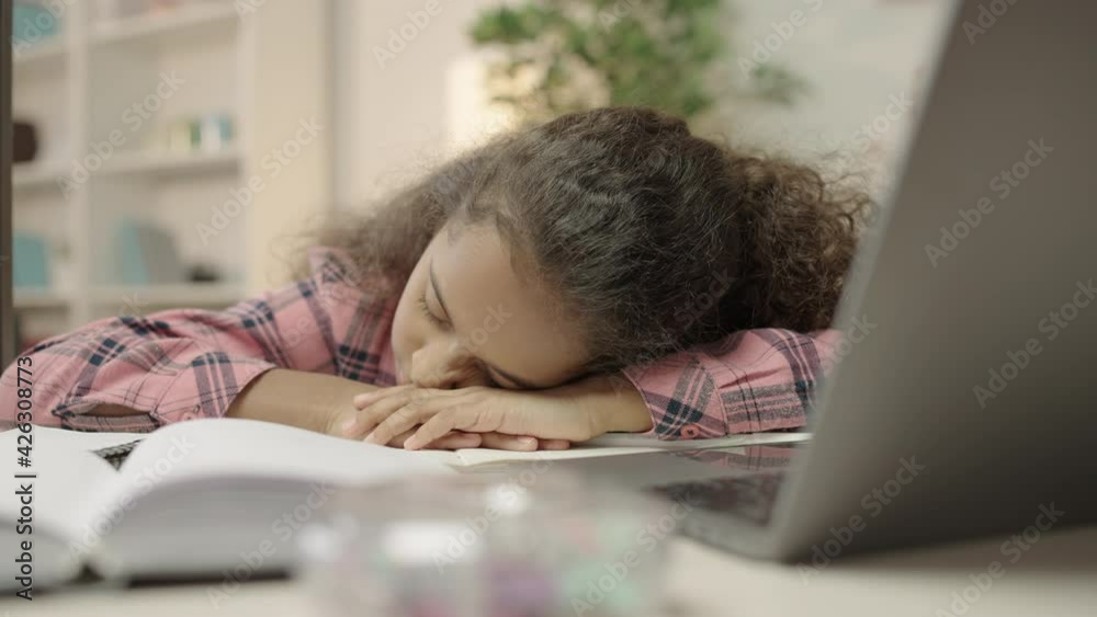 Schoolgirl sleeping at desk, tired of late night studying difficult lessons Schoolgirl sleeping at desk, tired of late night studying difficult lessons
