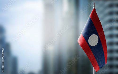 A small flag of Laos on the background of a blurred background