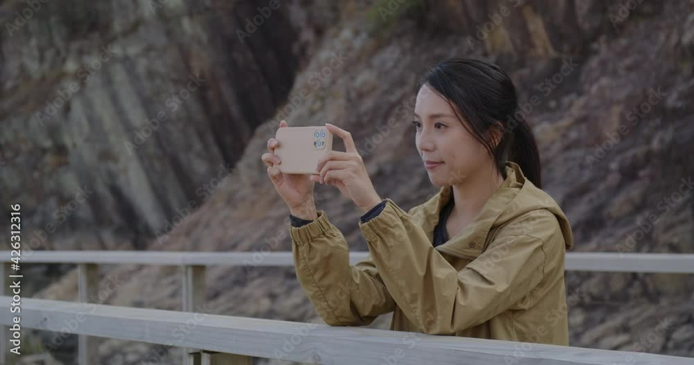 Woman take photo on cellphone in Geopark Woman take photo on cellphone in Geopark