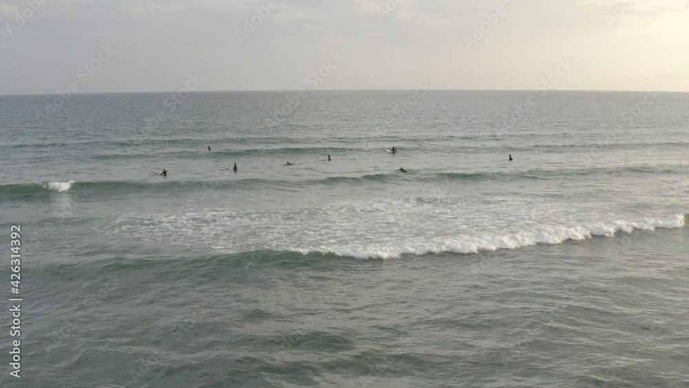 Some surfers practicing surfing during a small surf in katase enoshima japan. People in the ocean surfing when the wind is weak and waves are small. Some surfers practicing surfing during a small surf in katase enoshima japan. People in the ocean surfing when the wind is weak and waves are small.