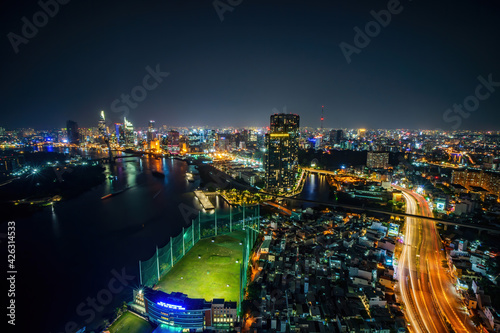Aerial view of Ho Chi Minh city, Vietnam. Beauty skyscrapers along river light smooth down urban development. Dramatic lighting spectacular night. © CravenA