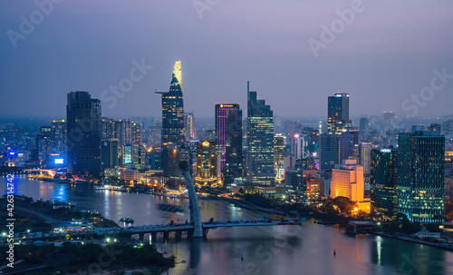 Aerial view of Ho Chi Minh city, Vietnam. Beauty skyscrapers along river light smooth down urban development. Dramatic lighting spectacular night. © CravenA