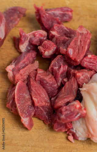 On the cutting board is beef cut into pieces