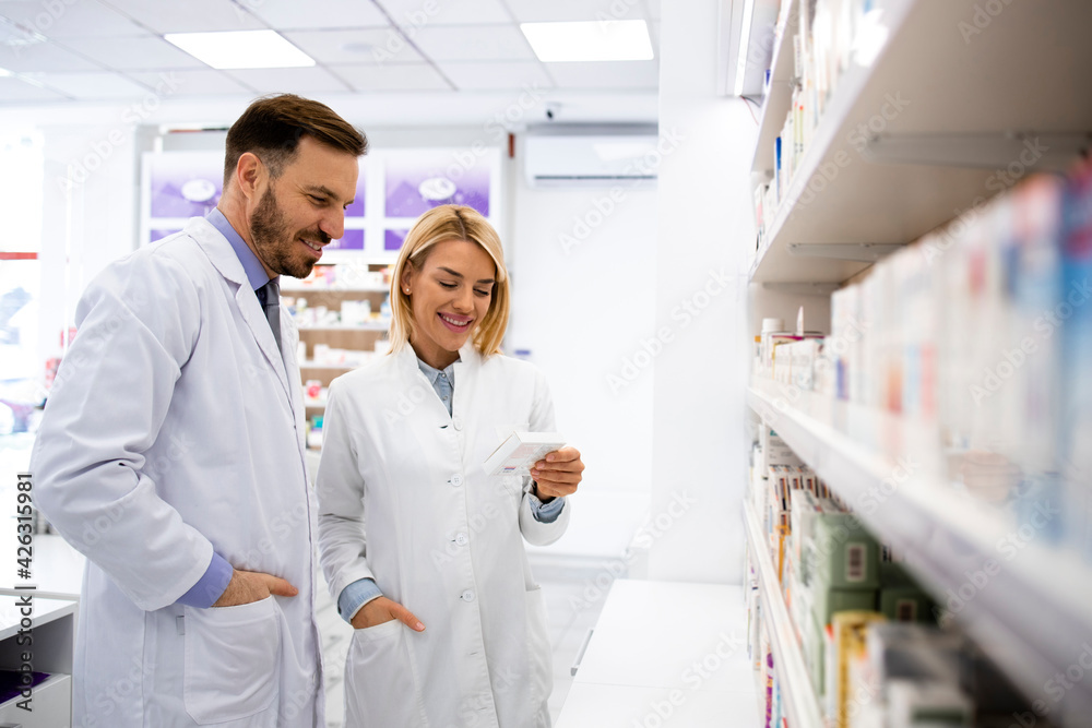 Pharmacists consulting each other about medicines in pharmacy store. Pharmacists consulting each other about medicines in pharmacy store.